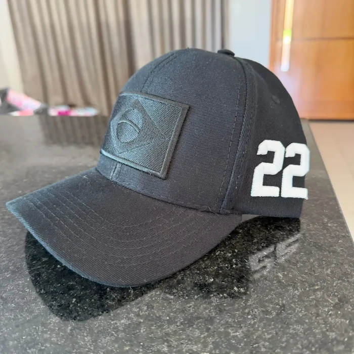 Boné preto do Brasil com bordado 22 sobre bancada de granito